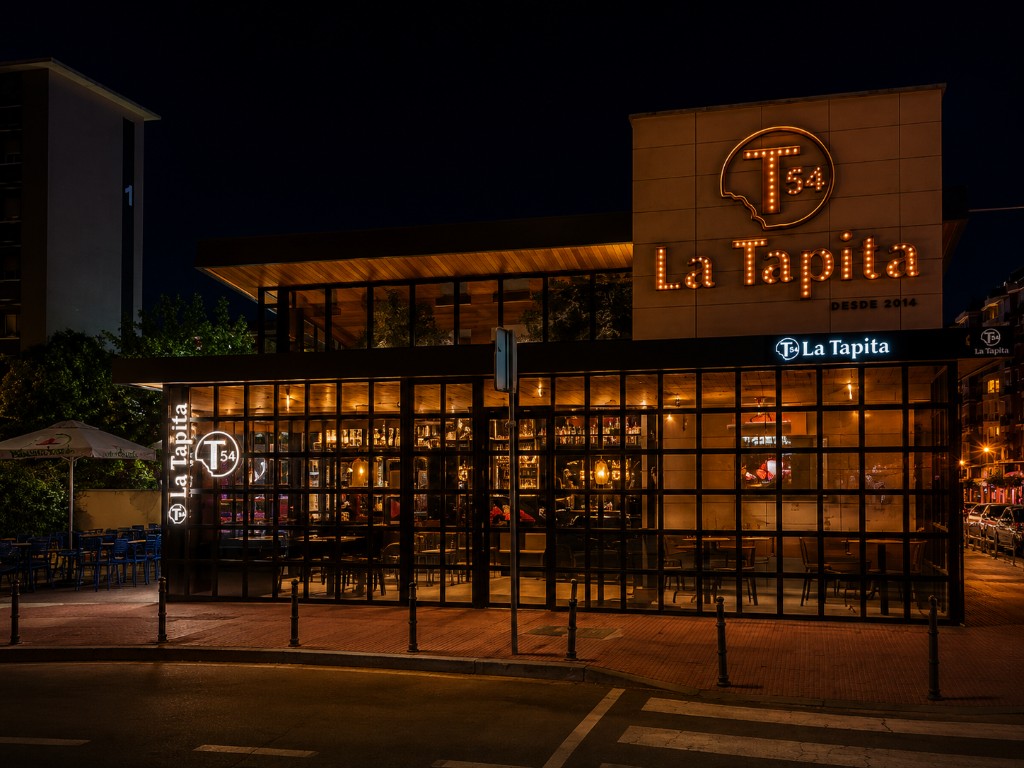 Fachada de T54 La Tapita de noche con neón